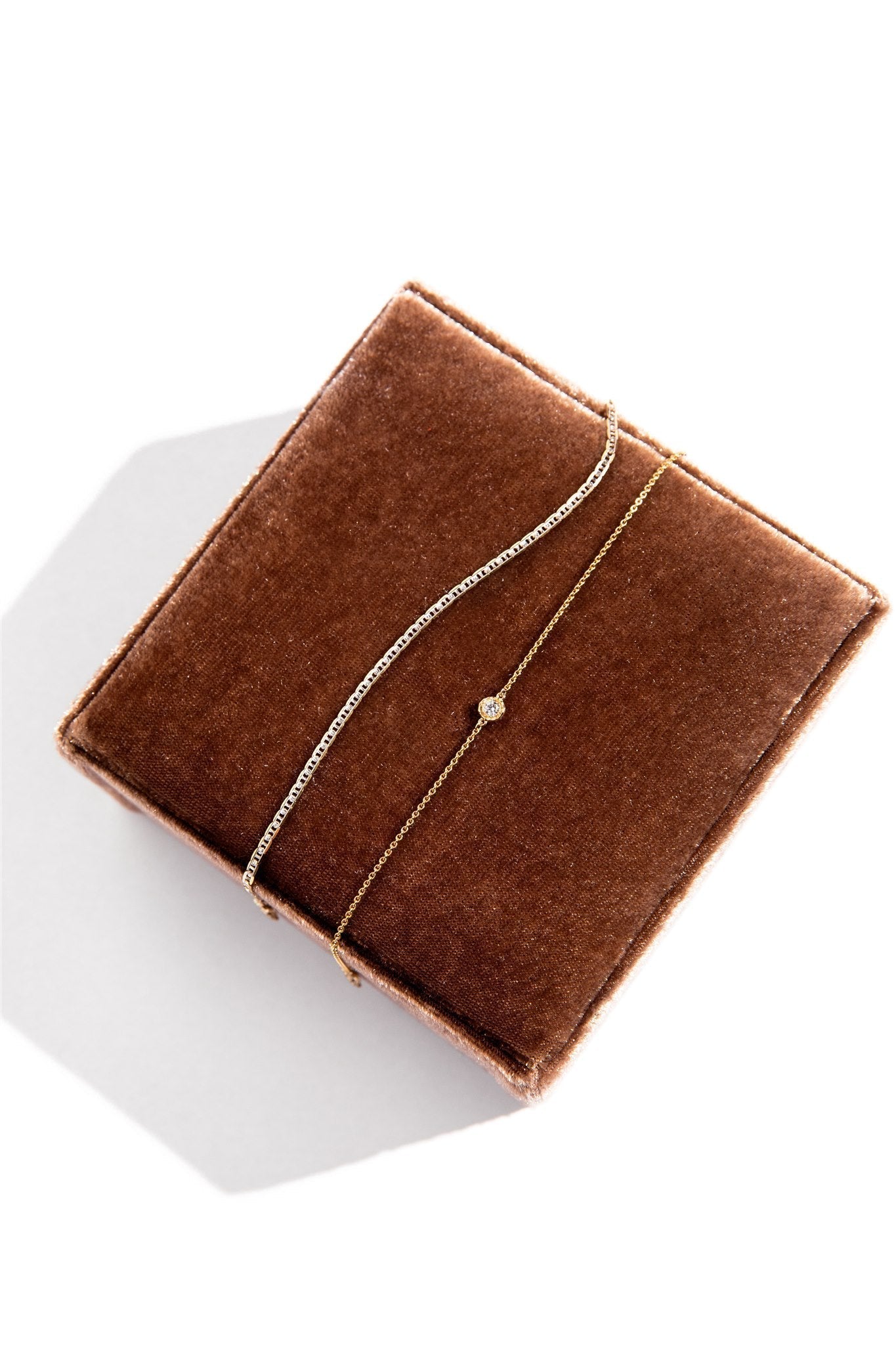 A brown velvet jewelry box that showcases loveweld bracelet styles. 